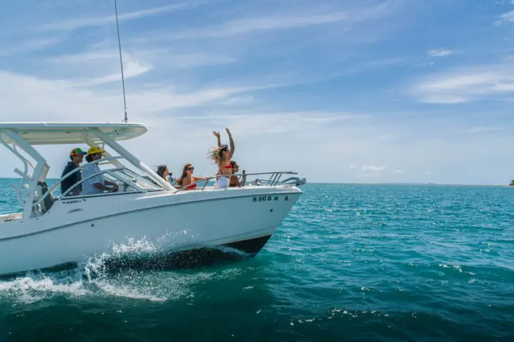 People on a motorboat enjoying the ocean under a clear sky.
